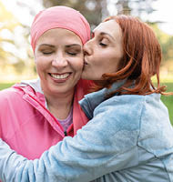 women hugging with closed eyes while kissing the fighter against cancer - concept fight against breast cancer -