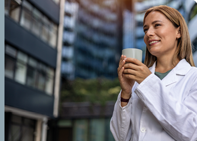 Shot of a young female doctor having a coffee while having break. Young female doctor in white coat on a coffee break.
