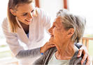 Health visitor and a senior woman during home visit. A nurse talking to an elderly woman.
