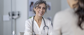 Une femme médecin à son bureau avec une patiente - MACSF
