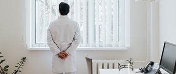 Un médecin de dos regarde à la fenêtre - MACSF