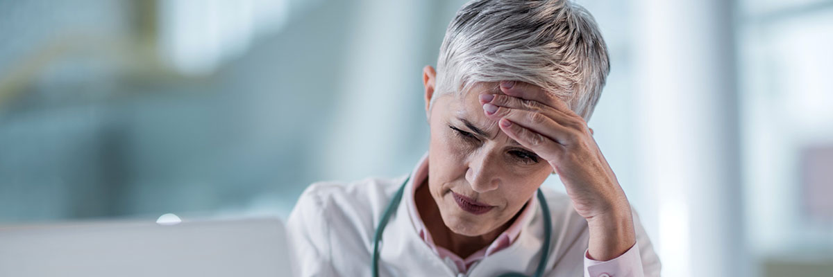 Une femme médecin se tient la tête - MACSF