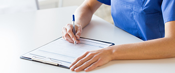 Une infirmière inscrit des informations sur un document - MACSF