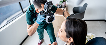 Un chirurgien-dentiste prend une photo de la bouche de sa patiente - MACSF