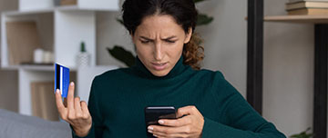 une femme consulte sont téléphone et constate une fraude à sa carte bancaire | MACSF