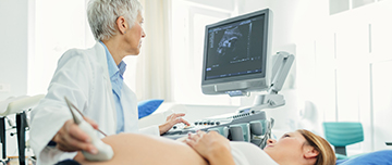Une femme médecin procède à un examen échographique sur une patiente enceinte - MACSF