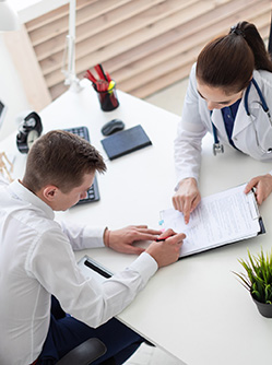 Un patient signe un document au cabinet médical - MACSF
