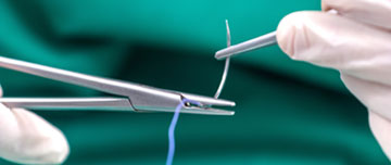 Mains d'infirmier tenant une pince et une aiguille de suture - MACSF