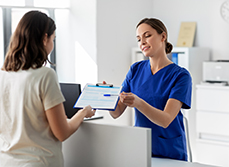 L'assistante présente un document au patient - MACSF