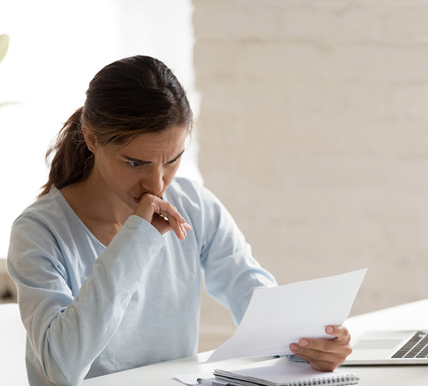 Une femme a son bureau inquiète lit un courrier - MACSF
