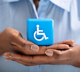 Une femme tient un cube avec le logo handicap entre ses mains - MACSF