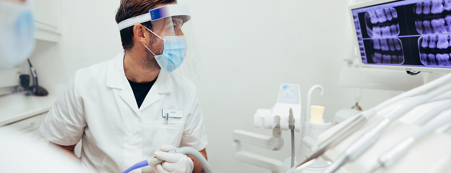 Un chirurgien dentiste observe la radiographie à l'écran - MACSF