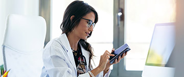 Une femme médecin écrit un message sur son téléphone - MACSF