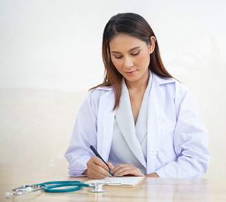 Une femme médecin en train d'écrire - MACSF