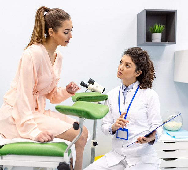 Une femme assise sur la table d'examen, discute avec le médecin - MACSF