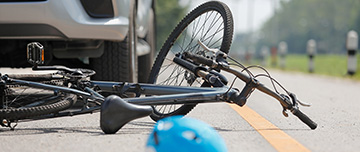 Une voiture arrêtée sur la route à côté d'un vélo accidenté - MACSF