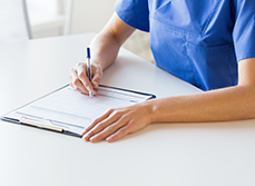 Une infirmière inscrit des informations sur un document - MACSF