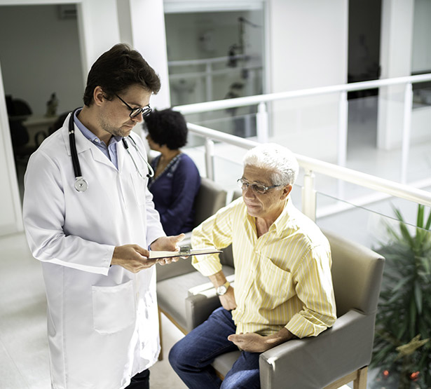 Un médecin discute avec un patient dans la salle d'attente de l'hôpital - MACSF