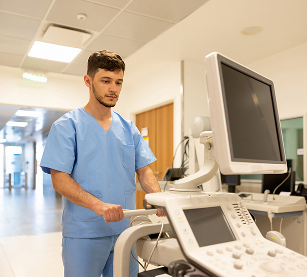 Un infirmier à l'hôpital poussant un moniteur médical - MACSF