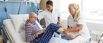 2 aides-soignants installent un malade dans sont lit  - MACSF