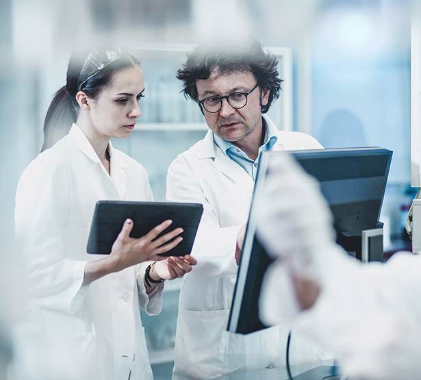 Un médecin et sa collaboratrice étudient un dossier sur ordinateur et tablette - MACSF