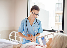 Une infirmière hospitalière prend le pouls d'une patiente alitée - MACSF