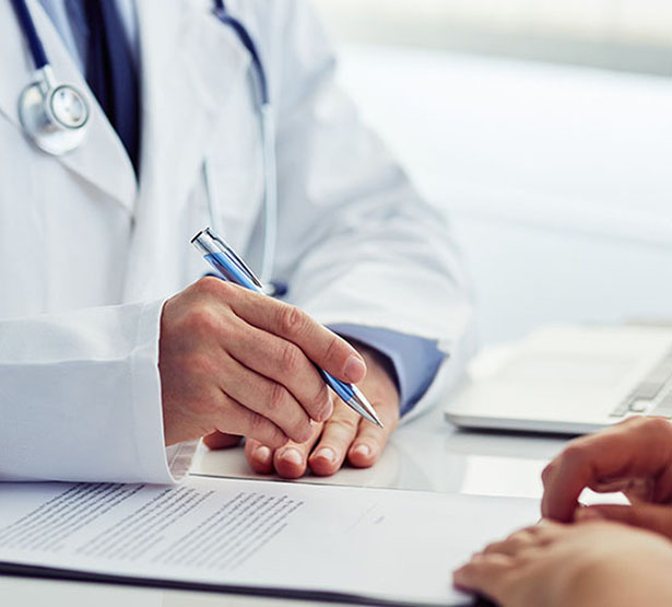 Un médecin complète un document face au patient - MACSF