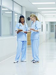 Deux agents hospitaliers discutent du dossier d'un patient - MACSF
