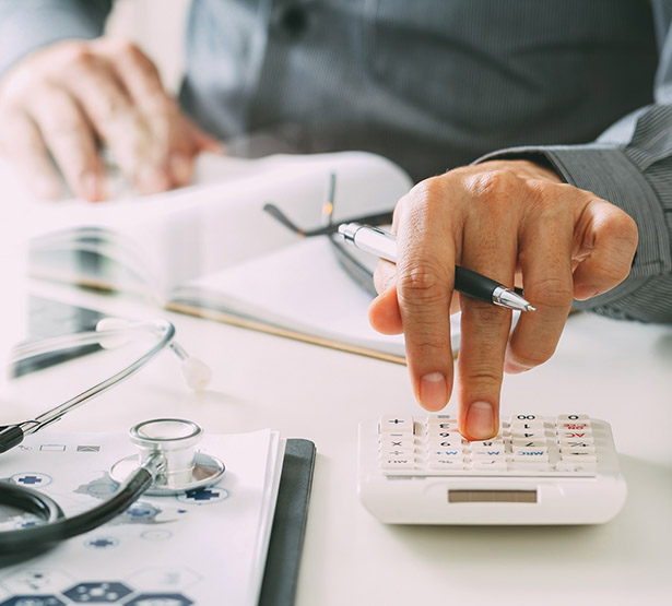 Un médecin tape sur sa calculatrice - MACSF
