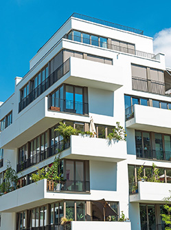 Haut d'un immeuble de copropriété sur fond de ciel bleu - MACSF