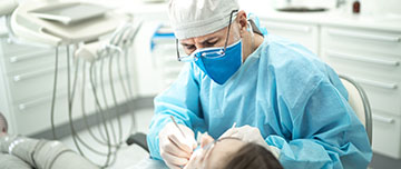 Un chirurgien-dentiste pratique des soins sur une patiente - MACSF