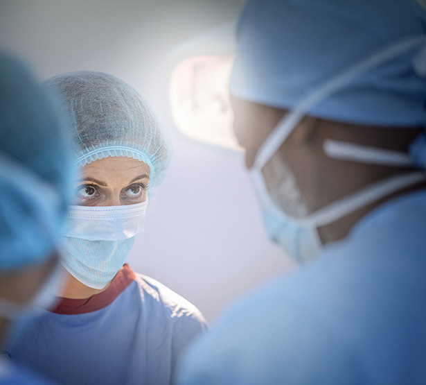 Une femme chirurgien regarde un de ses confrères lors d'une intervention - MACSF