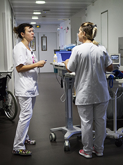 Une infirmière et une aide-soignante discutent dans le couloir de l'hôpital - MACSF