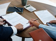 Gros plan sur une main qui s'apprête à signer un document à l'endroit désigné par son interlocuteur - MACSF