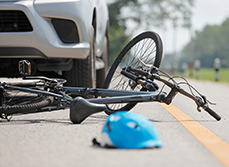 Une voiture arrêtée sur la route à côté d'un vélo accidenté - MACSF