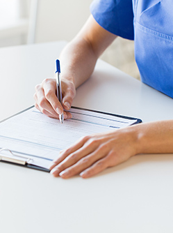 Une infirmière inscrit des informations sur un document - MACSF