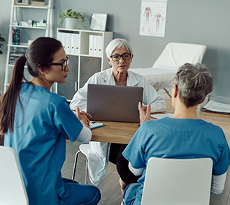 Des professionnels de santé examinent un dossier autour d'une table - MACSF