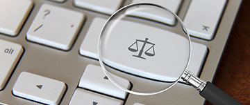 Loupe montrant le symbole d'une balance sur une touche de clavier d'ordinateur - MACSF