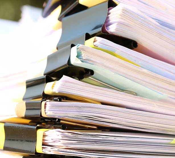 Gros plan sur les tranches d'une pile de dossiers colorés - MACSF