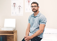 Un masseur-kinésithérapeute assis dans son cabinet - MACSF