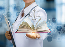 Un médecin tenant dans la main un code de déontologie ouvert - MACSF