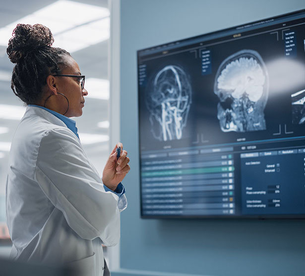 Une radiologue étudie des clichés radiologiques affichés à l'écran - MACSF