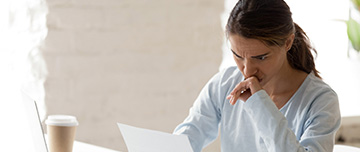 Une femme a son bureau inquiète lit un courrier - MACSF