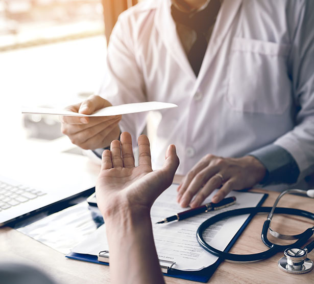 Un médecin tend un document au patient - MACSF