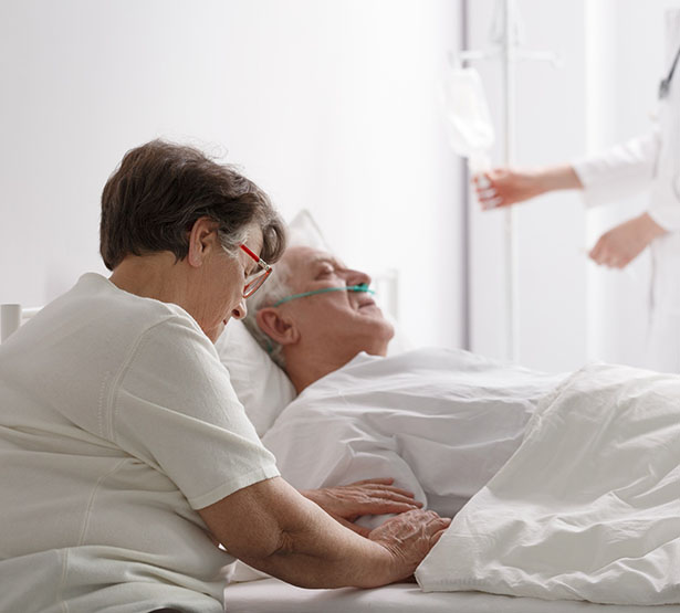 Une femme au chevet de son mari mourant sur le lit d'hôpital - MACSF