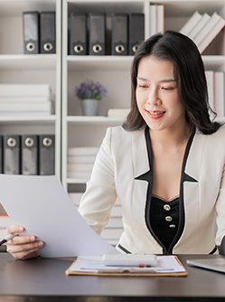 une professionnelle de santé observe un document installée à son bureau - MACSF