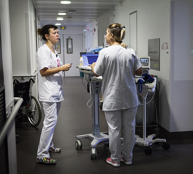 Une infirmière et une aide-soignante discutent dans le couloir de l'hôpital - MACSF
