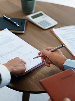 Gros plan sur une main qui s'apprête à signer un document à l'endroit désigné par son interlocuteur - MACSF