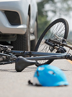 Une voiture arrêtée sur la route à côté d'un vélo accidenté - MACSF