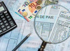 Des bulletins de paie sous une loupe et une calculatrice - MACSF